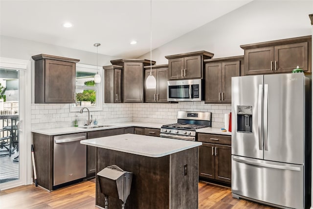2320 SE Maxwell Dr, Waukee, IA 50263 - kitchen featuring appliances with stainless steel finishes, a sink, dark brown cabinets, vaulted ceiling, and tasteful backsplash