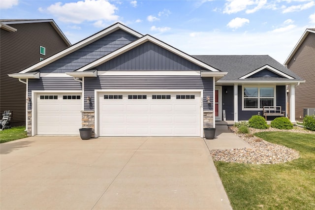2320 SE Maxwell Dr, Waukee, IA 50263 - view of front of house featuring a garage, stone siding, concrete driveway, and a front yard