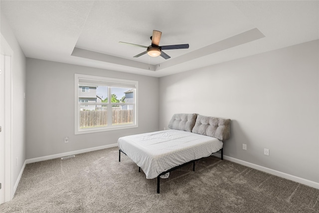 2320 SE Maxwell Dr, Waukee, IA 50263 - carpeted bedroom featuring a raised ceiling, baseboards, and a ceiling fan
