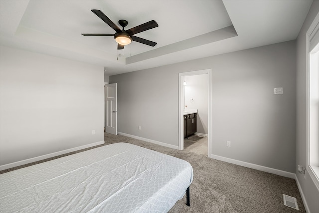 2320 SE Maxwell Dr, Waukee, IA 50263 - bedroom with a raised ceiling, light carpet, baseboards, and connected bathroom