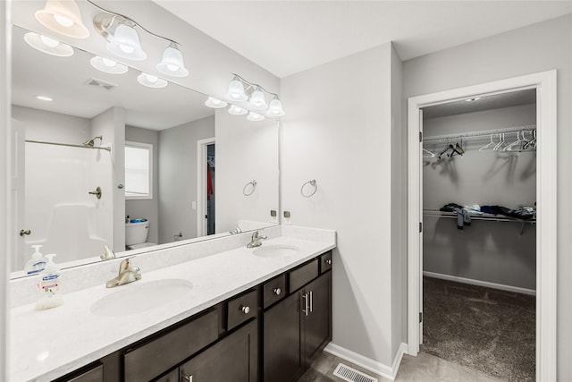 2320 SE Maxwell Dr, Waukee, IA 50263 - full bath featuring double vanity, toilet, a spacious closet, a shower, and baseboards