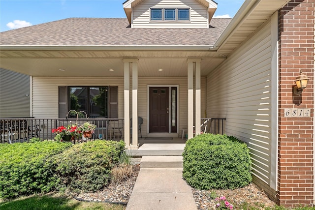 6814 Aubrey Ct, Johnston, IA 50131 - property entrance with a shingled roof, a porch, and brick siding