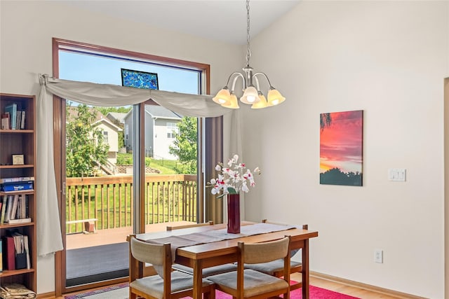 6814 Aubrey Ct, Johnston, IA 50131 - dining space with a chandelier, wood finished floors, baseboards, and lofted ceiling