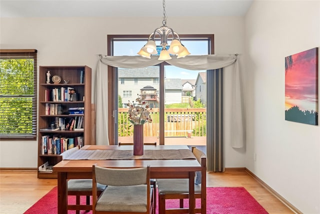 6814 Aubrey Ct, Johnston, IA 50131 - dining space with a chandelier, wood finished floors, and baseboards