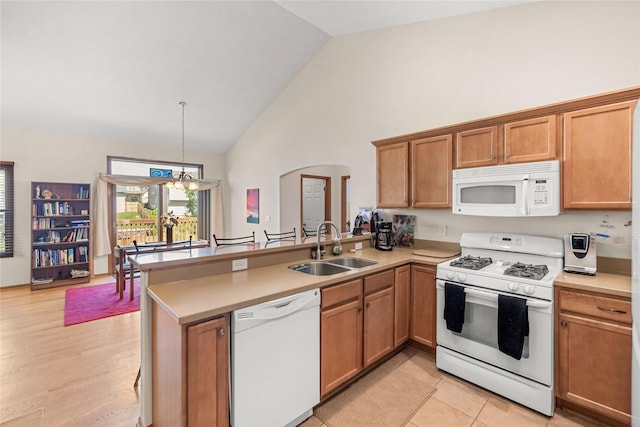 6814 Aubrey Ct, Johnston, IA 50131 - kitchen featuring white appliances, a sink, a peninsula, high vaulted ceiling, and a chandelier