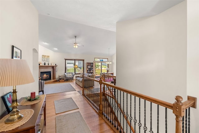 6814 Aubrey Ct, Johnston, IA 50131 - hallway with an upstairs landing, wood finished floors, and vaulted ceiling