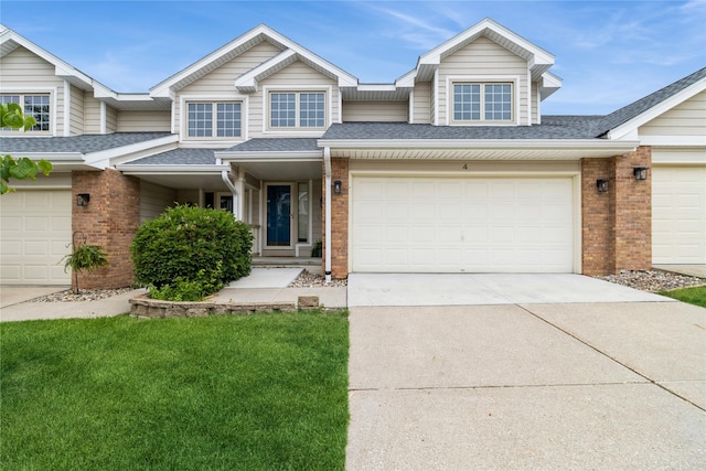 4400 Ep True Pkwy Unit 4, West Des Moines, IA 50265 - townhome / multi-family property with brick siding, a shingled roof, driveway, a front yard, and an attached garage
