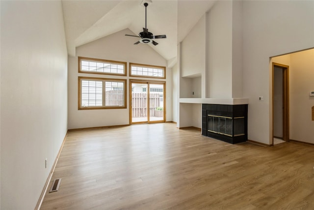 4400 Ep True Pkwy Unit 4, West Des Moines, IA 50265 - unfurnished living room featuring a ceiling fan, high vaulted ceiling, a tile fireplace, baseboards, and wood finished floors