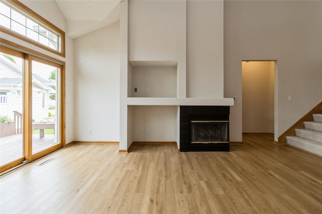 4400 Ep True Pkwy Unit 4, West Des Moines, IA 50265 - unfurnished living room featuring high vaulted ceiling, wood finished floors, stairway, a fireplace, and baseboards