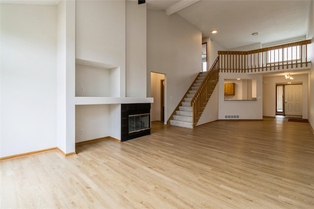 4400 Ep True Pkwy Unit 4, West Des Moines, IA 50265 - unfurnished living room featuring high vaulted ceiling, stairs, wood finished floors, beamed ceiling, and baseboards