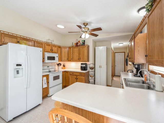 812 W 2nd St S, Newton, IA 50208 - kitchen with white appliances, a sink, a peninsula, a ceiling fan, and light countertops