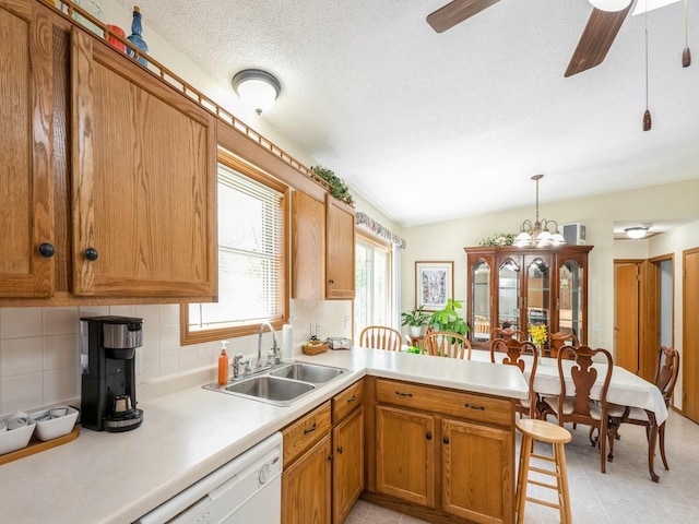 812 W 2nd St S, Newton, IA 50208 - kitchen featuring a sink, a peninsula, light countertops, white dishwasher, and a textured ceiling