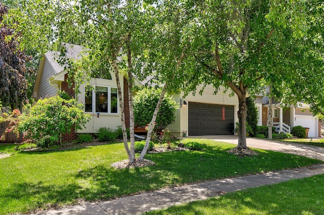 4670 Meadow Valley Dr, West Des Moines, IA 50265 - obstructed view of property with concrete driveway, a front yard, an attached garage, and brick siding