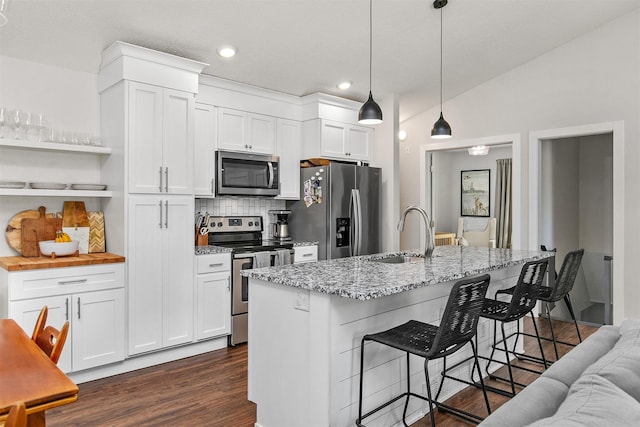 4670 Meadow Valley Dr, West Des Moines, IA 50265 - kitchen featuring stainless steel appliances, a sink, dark wood finished floors, decorative backsplash, and white cabinets
