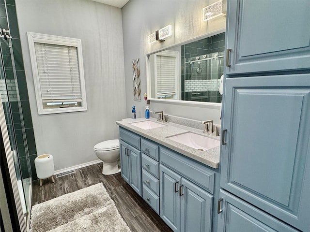 1008 Pine Brooke Ct, Clear Lake, IA 50428 - bathroom with toilet, double vanity, a shower stall, and wood finished floors