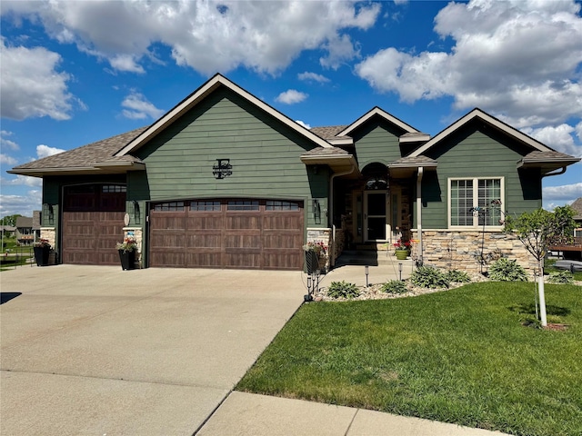 1008 Pine Brooke Ct, Clear Lake, IA 50428 - view of front of property featuring a garage, driveway, a front yard, stone siding, and a shingled roof