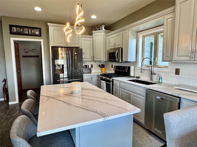 1008 Pine Brooke Ct, Clear Lake, IA 50428 - kitchen with stainless steel appliances, a sink, a kitchen island, tasteful backsplash, and recessed lighting
