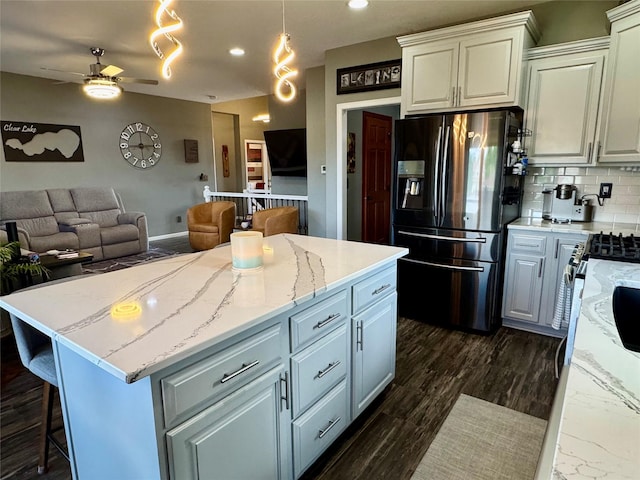 1008 Pine Brooke Ct, Clear Lake, IA 50428 - kitchen featuring refrigerator with ice dispenser, ceiling fan, open floor plan, tasteful backsplash, and a center island