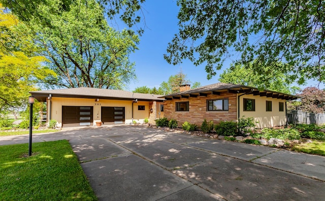 201 Jet St SW, Mitchellville, IA 50169 - view of front facade featuring a chimney, a garage, and concrete driveway