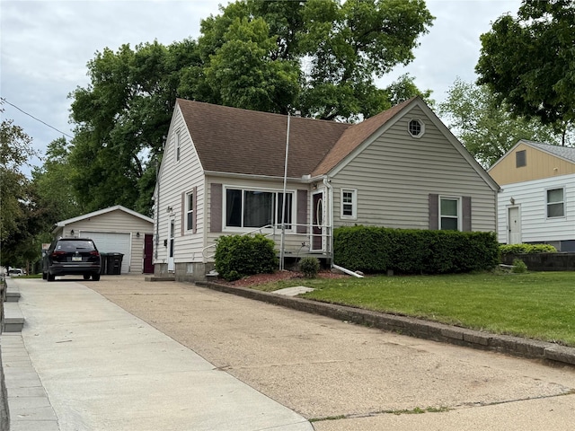 1300 Shawnee Ave, Des Moines, IA 50313 - view of front of house with an outdoor structure, a detached garage, a front yard, and roof with shingles