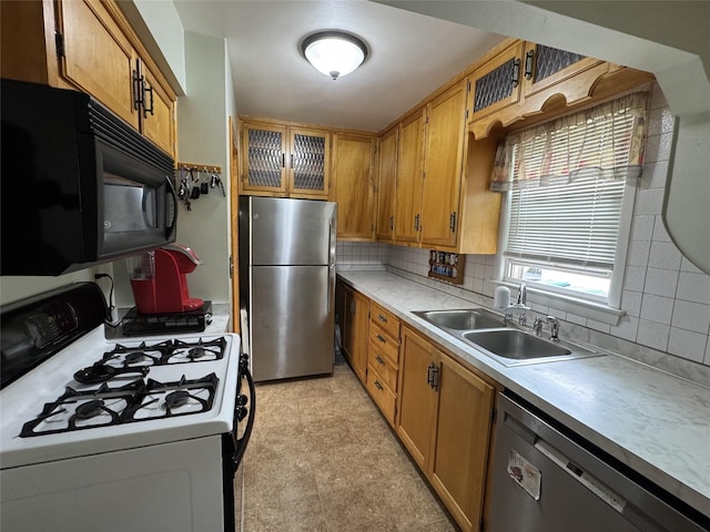 1300 Shawnee Ave, Des Moines, IA 50313 - kitchen with appliances with stainless steel finishes, a sink, decorative backsplash, light countertops, and brown cabinets
