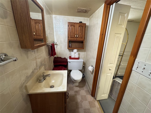 1300 Shawnee Ave, Des Moines, IA 50313 - bathroom featuring vanity, tile walls, and toilet