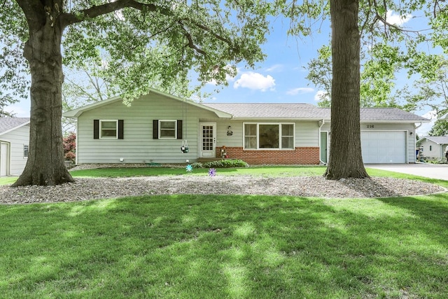 216 E 9th St, Pella, IA 50219 - ranch-style home featuring a garage, driveway, brick siding, and a front yard