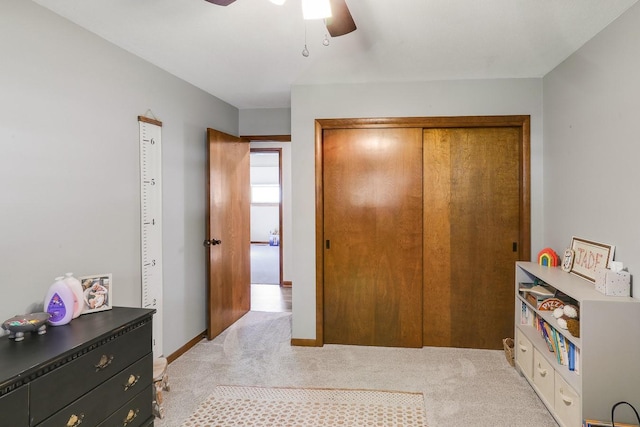 216 E 9th St, Pella, IA 50219 - bedroom featuring light carpet, a closet, a ceiling fan, and baseboards