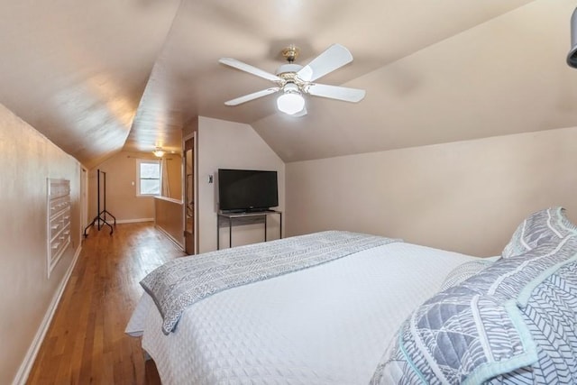 6100 College Ave, Des Moines, IA 50322 - bedroom featuring wood finished floors, lofted ceiling, baseboards, and a ceiling fan