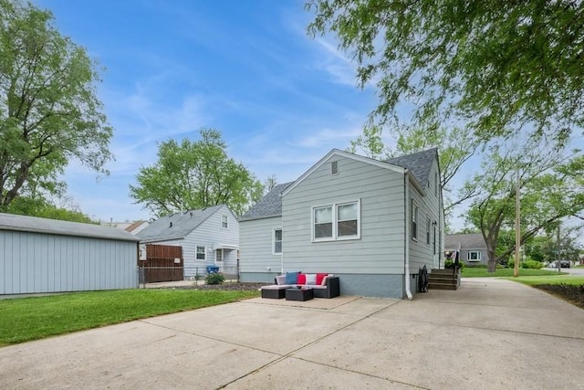 6100 College Ave, Des Moines, IA 50322 - rear view of house featuring a shingled roof, a patio area, an outdoor hangout area, and driveway