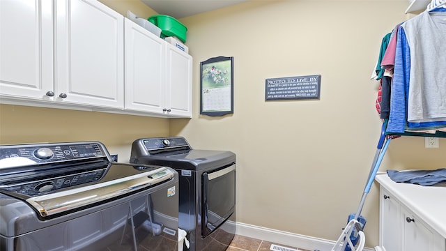 510 Lexington Dr, Clear Lake, IA 50428 - laundry area featuring independent washer and dryer, cabinet space, baseboards, and tile patterned floors