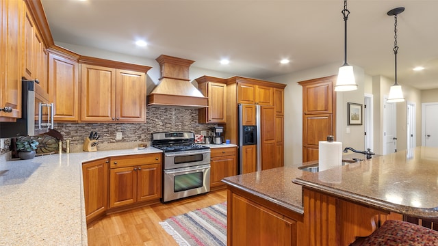 510 Lexington Dr, Clear Lake, IA 50428 - kitchen featuring stainless steel appliances, custom range hood, brown cabinetry, tasteful backsplash, and recessed lighting