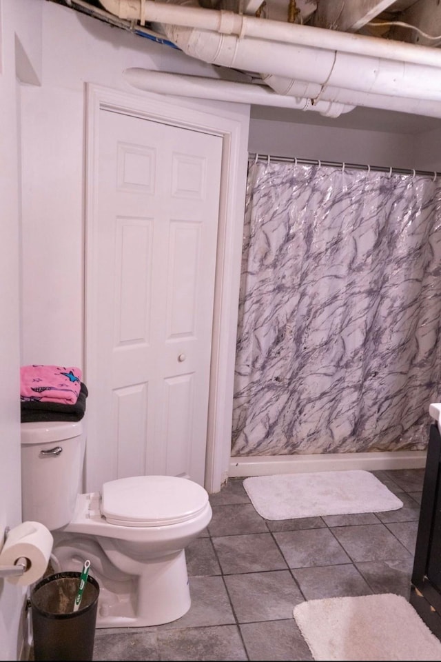 2326 E 39th Ct, Des Moines, IA 50317 - bathroom with toilet, curtained shower, and tile patterned flooring