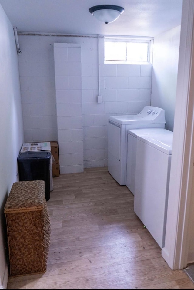 2326 E 39th Ct, Des Moines, IA 50317 - laundry room with washer and clothes dryer, light wood finished floors, and concrete block wall