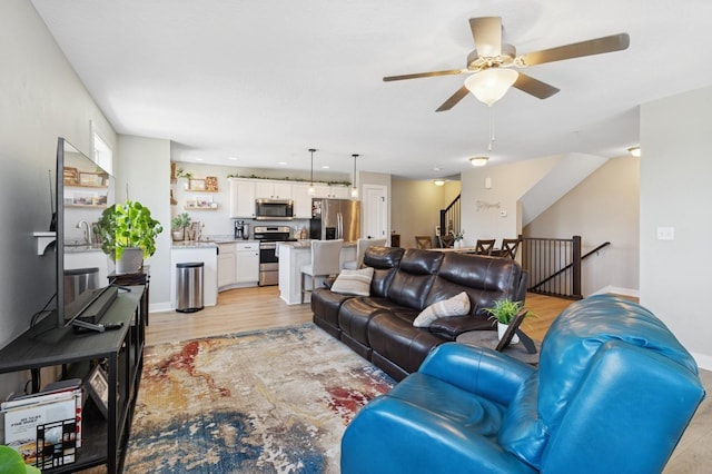 247 Red Oak Ct, Norwalk, IA 50211 - living room with ceiling fan, light wood-style floors, and baseboards