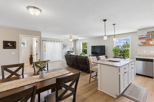247 Red Oak Ct, Norwalk, IA 50211 - dining space featuring a textured ceiling, light wood-type flooring, and ceiling fan