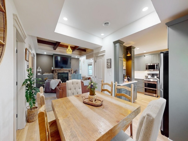 1314 Glenway Dr, Newton, IA 50208 - dining space with light wood-type flooring, a brick fireplace, beam ceiling, recessed lighting, and coffered ceiling