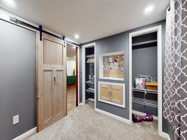 1314 Glenway Dr, Newton, IA 50208 - carpeted bedroom featuring a barn door, multiple closets, and baseboards