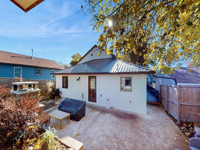 1314 Glenway Dr, Newton, IA 50208 - back of property with a patio, a fenced backyard, and metal roof