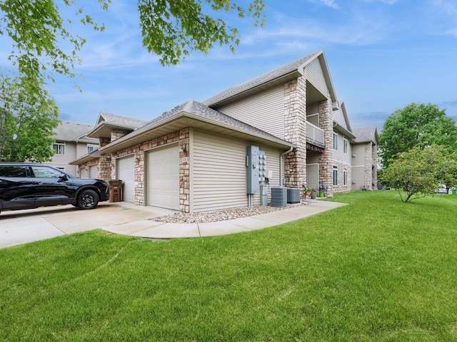 528 Kelsey Ln, Altoona, IA 50009 - view of side of property with stone siding, an attached garage, a yard, driveway, and central air condition unit