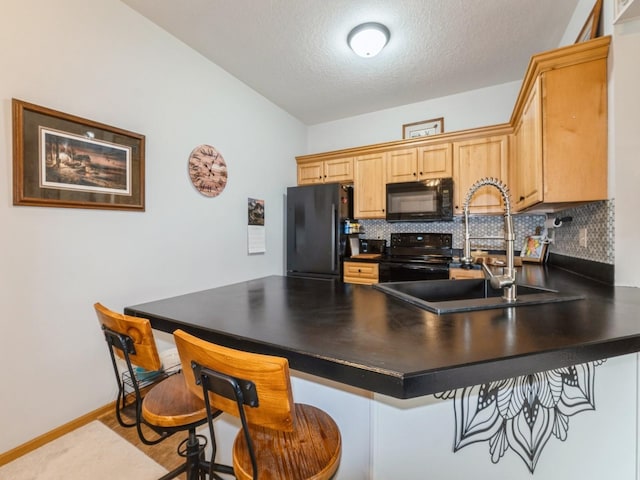 528 Kelsey Ln, Altoona, IA 50009 - kitchen featuring black appliances, dark countertops, a sink, a peninsula, and backsplash