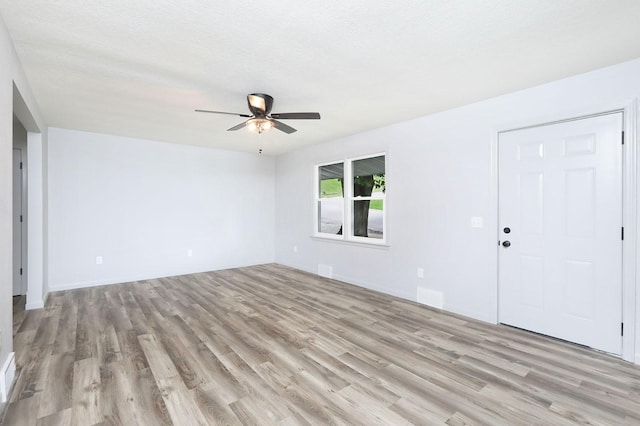314 E Front St, Colfax, IA 50054 - empty room with light wood-style floors, ceiling fan, and baseboards