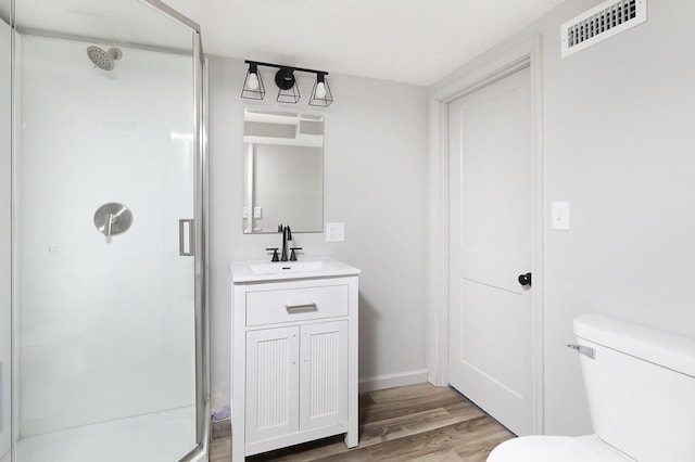 314 E Front St, Colfax, IA 50054 - bathroom with a shower stall, wood finished floors, toilet, vanity, and baseboards