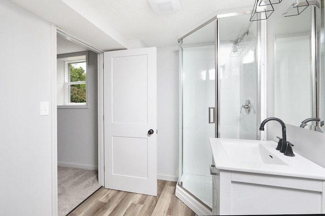 314 E Front St, Colfax, IA 50054 - full bath with wood finished floors, vanity, a stall shower, and baseboards
