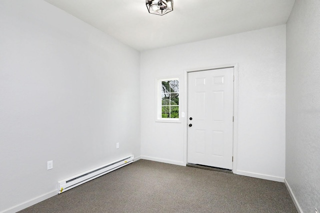 314 E Front St, Colfax, IA 50054 - unfurnished room featuring baseboard heating, dark colored carpet, and baseboards