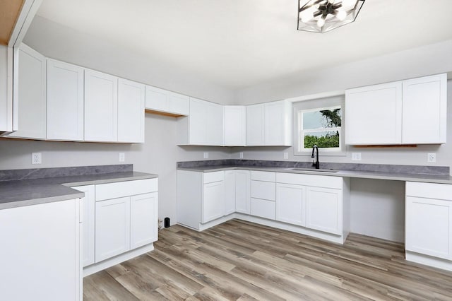 314 E Front St, Colfax, IA 50054 - kitchen featuring a sink, light wood-style flooring, and white cabinets