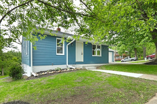 314 E Front St, Colfax, IA 50054 - bungalow-style home featuring a front yard, a chimney, and a garage