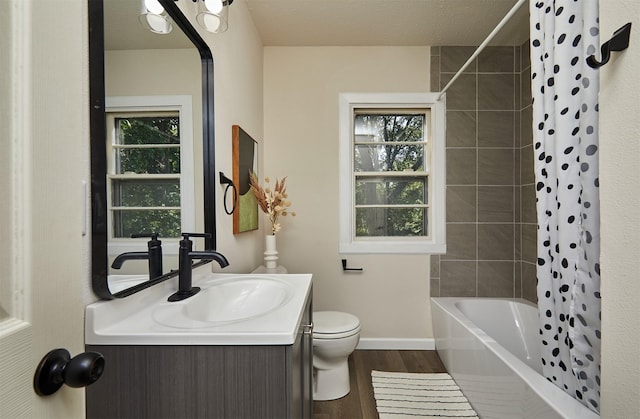 2112 E 23rd St, Des Moines, IA 50317 - bathroom with toilet, wood finished floors, vanity, shower / bath combo, and baseboards