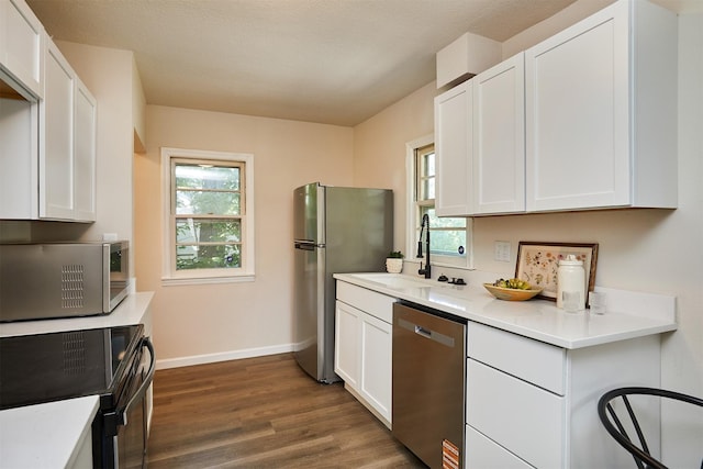 2112 E 23rd St, Des Moines, IA 50317 - kitchen featuring stainless steel appliances, a sink, dark wood finished floors, light countertops, and white cabinets