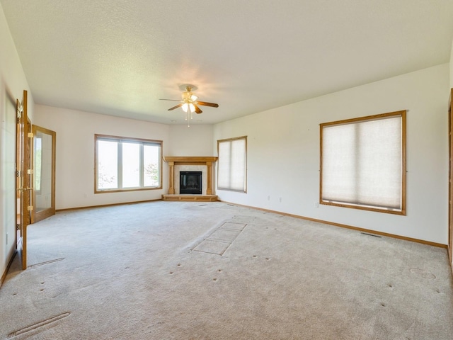 2117 W 4th Ave, Indianola, IA 50125 - unfurnished living room featuring a ceiling fan, carpet, baseboards, and a tiled fireplace